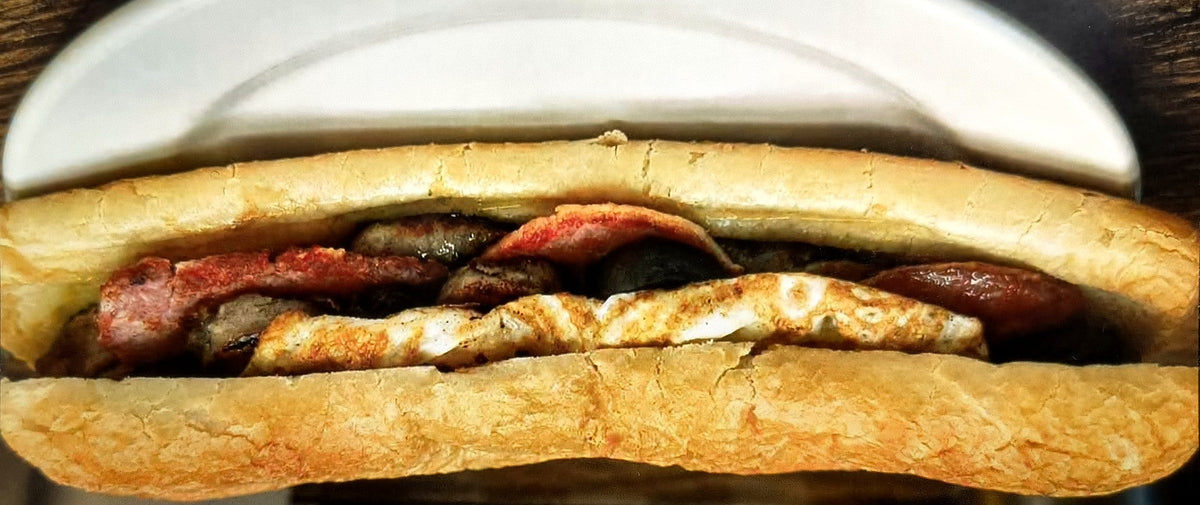 Breakfast roll with sausage, rasher, pudding and fried egg