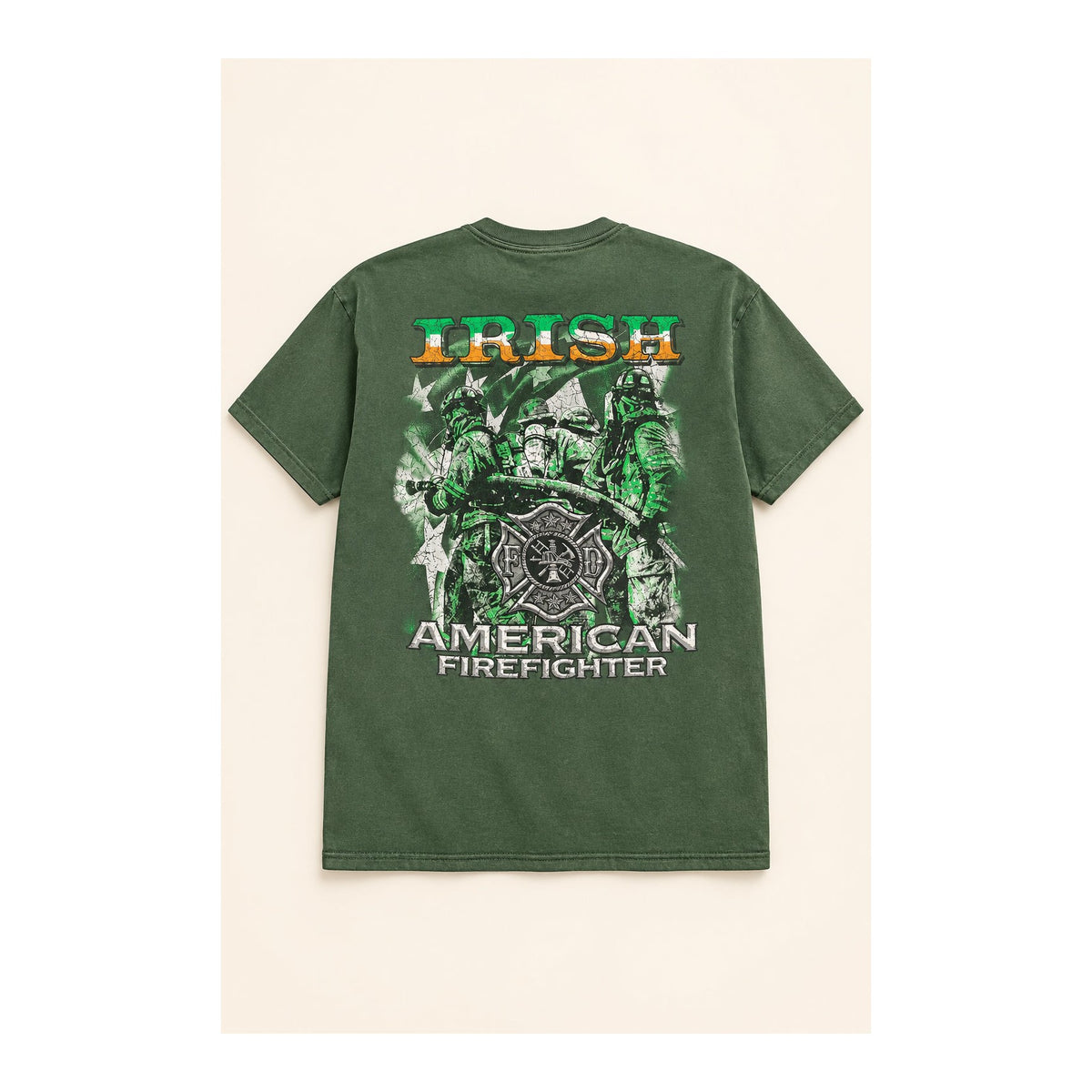 An olive green short-sleeve graphic t-shirt laid flat on a dark table. The shirt features a large graphic print of firefighters with a Maltese cross, the text 'AMERICAN FIREFIGHTER' in white, and 'IRISH' written vertically in green, yellow, and white.